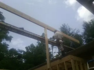 Carpenter setting a ridge beam over a new addition frame — Ice Dam Removal by Roofing Brothers in Trumbauersville