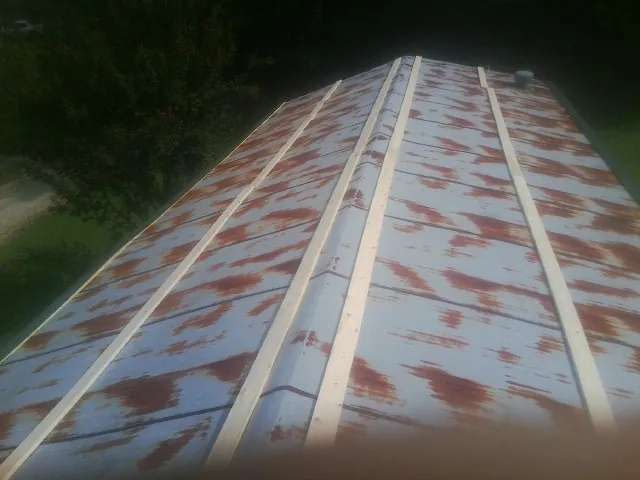Rusted metal roof panels with new wood purlins before replacement — Storm Damage Roof Repair in Trumbauersville by Roofing Brothers