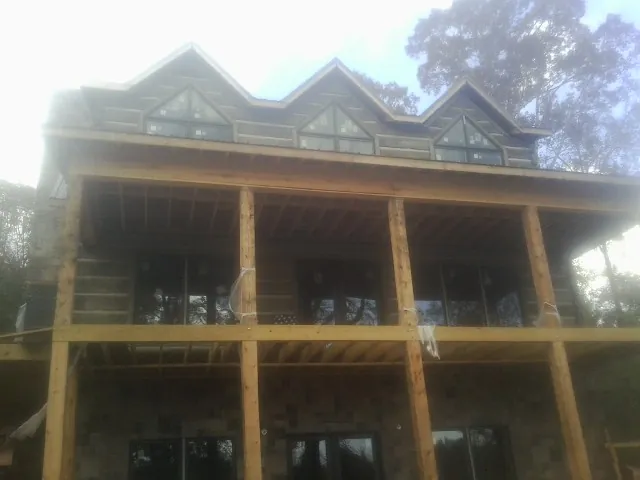 Dormers and porch framing on a large log home under construction — Roof Coating work by our crew in Trumbauersville