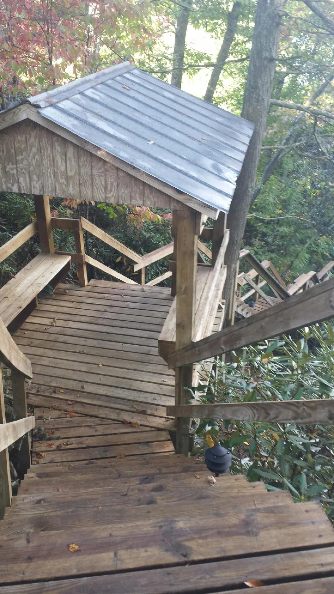 Metal roofed shelter over wooden steps on a wooded walkway — Skylight Repair & Installation work by our crew in Trumbauersville