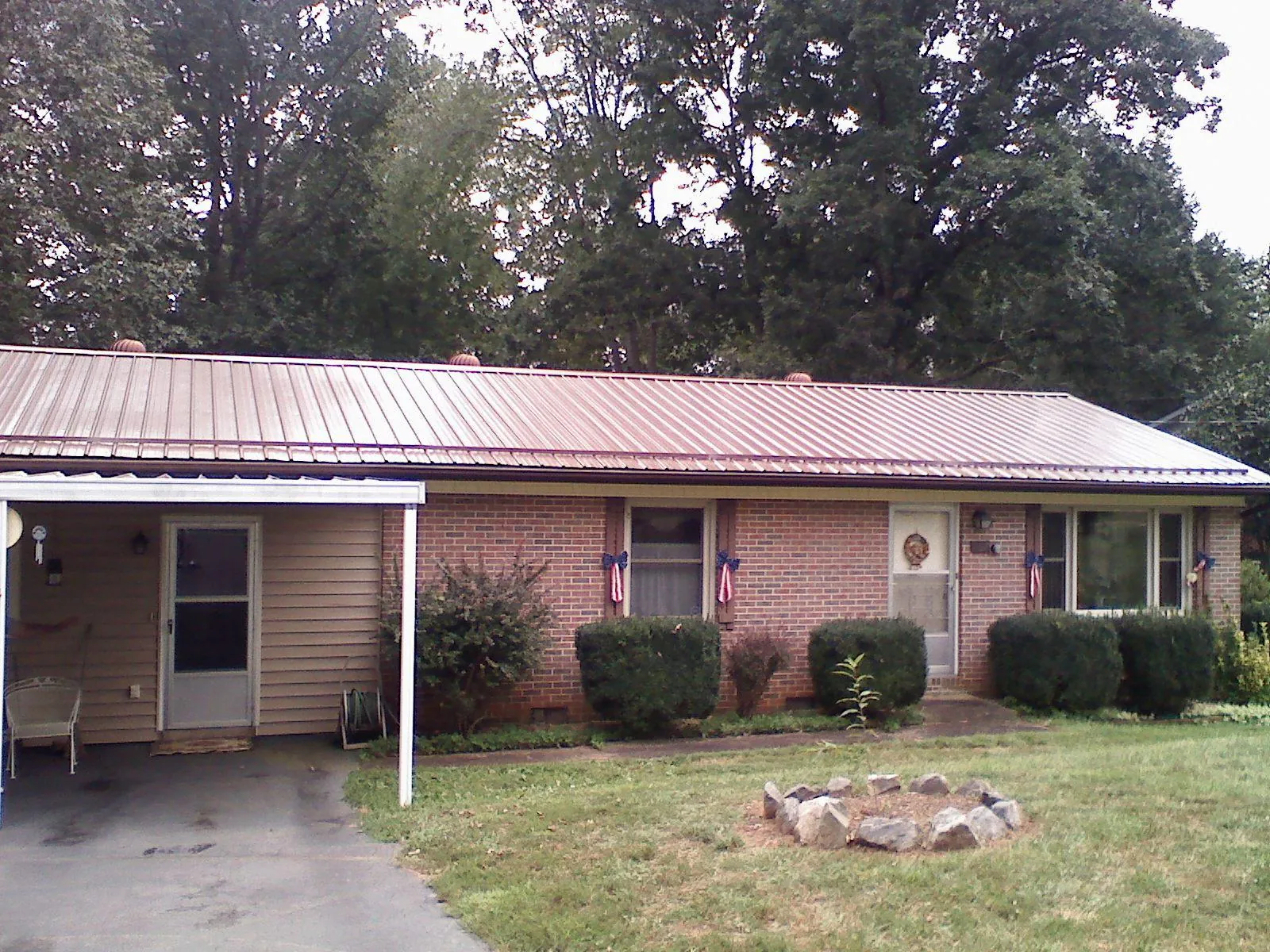 Bronze metal roof and carport on a brick ranch home — Roof Repair work by our crew in Trumbauersville